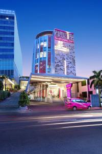 a pink car parked in front of a building at favehotel Madiun in Madiun