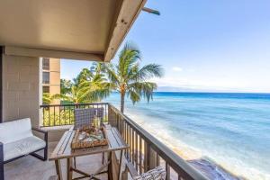 uma varanda com uma mesa e cadeiras e o oceano em Maui Kai 301- Stunning Oceanfront Corner Condo at North Kaanapali Beach em Kahana