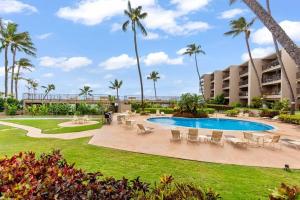 a resort with a swimming pool and palm trees at Hale Ono Loa 114- Ground floor partial ocean view gem in Kahana