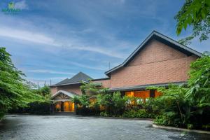 古瓦哈提Mayfair Spring Valley Resort Guwahati的一栋前面有砖砌车道的房子
