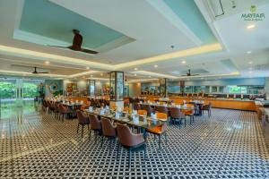 una sala da pranzo con tavoli e sedie in un ristorante di Mayfair Spring Valley a Guwahati