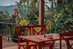 a wooden table and two chairs on a deck at Padangan Lodge By Bali Cabin in Padangan