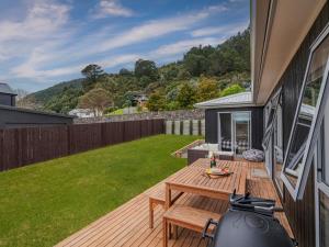 a backyard with a wooden table and a lawn at A Sunshine Retreat - Pauanui Holiday Home in Pauanui