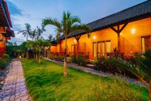 una casa con una palma di fronte a un cortile di Ba Bar Cottage Penida a Nusa Penida