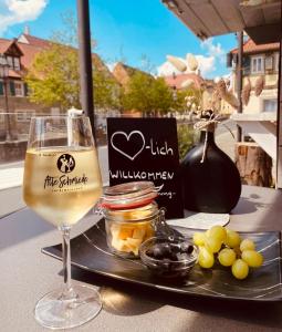 una copa de vino en una mesa con un plato de comida en Aparthotel Alte Schmiede Dettelbach, en Dettelbach