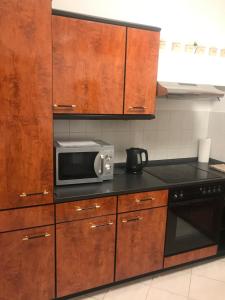 a kitchen with wooden cabinets and a microwave at Ferienwohnung über Greiz in Greiz