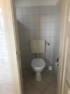 a bathroom with a toilet in a tiled room at Ferienwohnung über Greiz in Greiz