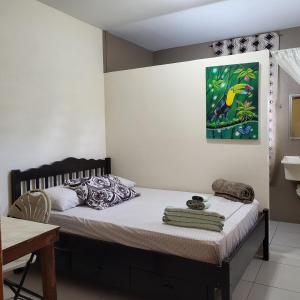 - une chambre avec un lit et une peinture murale dans l'établissement Hacienda Tropical Guest House, à Belmopan