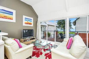 een woonkamer met 2 witte stoelen en een tv bij Fantastic Beachside Townhouse in Victor Harbor