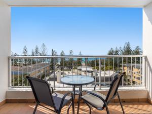 patio con mesa y sillas en el balcón en Mariner Shores Club, en Gold Coast