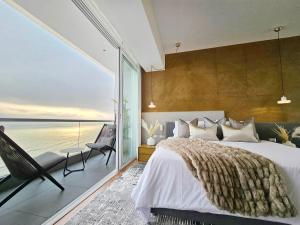 a bedroom with a large bed and a view of the ocean at Penthouse Waterfront Private Pool in Lima