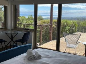 1 dormitorio con cama y vistas a un patio en Cape Schanck Golf and Ocean Views Holiday Villa, en Cape Schanck
