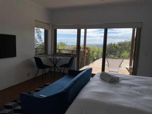 1 dormitorio con cama y vistas a un patio en Cape Schanck Golf and Ocean Views Holiday Villa, en Cape Schanck