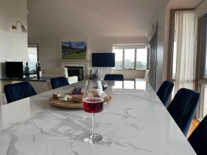 una mesa con una copa de vino sentada en ella en Cape Schanck Golf and Ocean Views Holiday Villa, en Cape Schanck