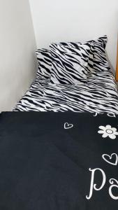 a bed with a black and white comforter on it at Comfy zone in Abu Dhabi