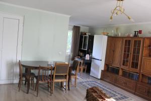 a kitchen with a table and chairs and a white refrigerator at Nunuka House in Tserovani