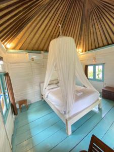 a bed in a room with a roof at Kubu Di Omo Villas in Munggu