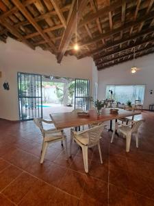 a dining room with a large wooden table and chairs at Casa con alberca, cerca del rio in Jalcomulco
