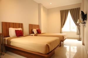 una camera d'albergo con due letti e una finestra di Bale Ocasa a Tangerang