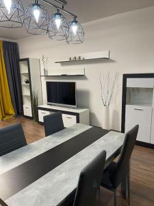 a dining room with a table and chairs and a television at Y&Y apartments in Bratislava