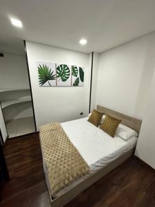 een slaapkamer met een bed met witte lakens en kussens bij apt duplex embajada americana corferias agora g12 in Bogota