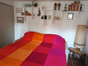 a bedroom with a colorful blanket on a bed at Annexe indépendante in Bourron-Marlotte