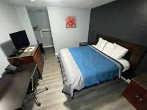 a bedroom with a bed and a desk and a computer at Reed Motel Nashville in Nashville +1 photo