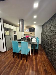 a kitchen with a dining room table and blue chairs at apt duplex embajada americana corferias agora g12 in Bogotá