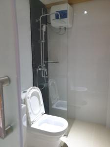 e bagno con servizi igienici bianchi e doccia. di Fanfini Residence Male’ a Città di Malé