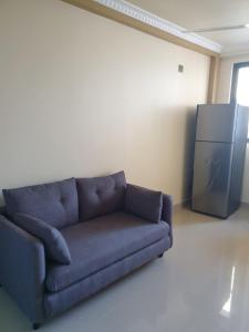 a blue couch in a room with a refrigerator at Fanfini Residence Male’ in Male City