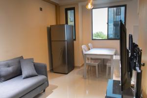 a living room with a couch and a table and a refrigerator at Fanfini Residence Male’ in Male City