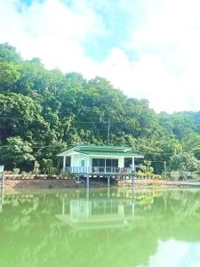una casa seduta sul fianco di un corpo d'acqua di บังกะโลบ้านสวนเอก Bungalow Baan Suan Aek 