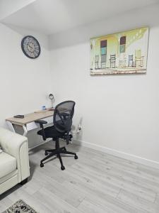 an office with a desk and a chair and a clock at New built house, Stay in Style Guest Suite, 2bedroom, 2bed, 2bath in Edmonton