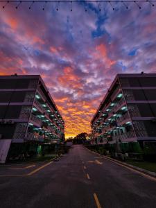 an empty street with a sunset behind twoartment buildings at Zaque's Hotel in Sungai Petani