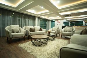 a waiting room with couches and a table and chairs at Zaque's Hotel in Sungai Petani