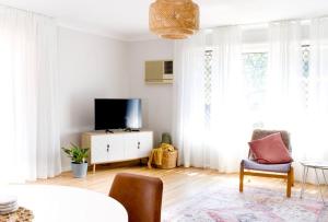 sala de estar con cortinas blancas y TV en Spacious Two-Bedroom Retreat, en Ipswich