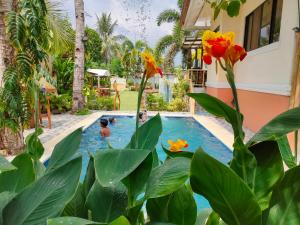 un hombre en una piscina en un patio con flores en Sanset Villa 1 and 2 en Alburquerque