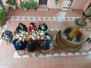 Un groupe de personnes assises à une table et mangeant de la nourriture dans l'établissement Hostal Juanita, à Vallegrande