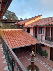 a balcony of a house with a red tile roof at Hostal Juanita in Vallegrande