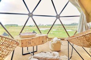 a tent with a table and chairs and a view at FARMGLAMP in Balneario Buenos Aires