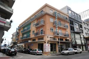 a large building with cars parked in front of it at Hotel Avra in Volos