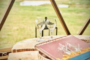 dos copas de vino sentadas sobre una mesa en FARMGLAMP en Balneario Buenos Aires