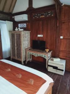 1 dormitorio con 2 camas y una mesa pequeña en Buratwangi Joglo House, en Kerobokan
