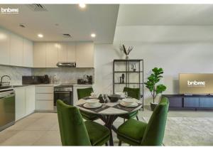 een keuken met een eettafel en groene stoelen bij bnbmehomes - Access to Madinat Jumeirah Living - 404 in Dubai