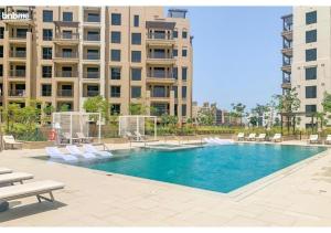 een zwembad met witte stoelen en een gebouw bij bnbmehomes - Access to Madinat Jumeirah Living - 404 in Dubai