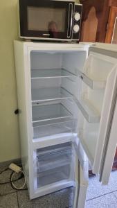 an empty refrigerator with a microwave on top of it at Gästezimmer Lea mit Gemeinschaftsbad in Hausbreitenbach