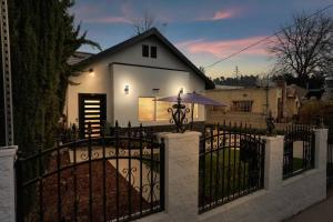 a white house with a fence and an umbrella at Family/pet friendly home near Hollywood & Pasadena in Los Angeles