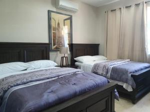 a bedroom with two beds and a window at lovely gated 3 BEDROOM in Kingston