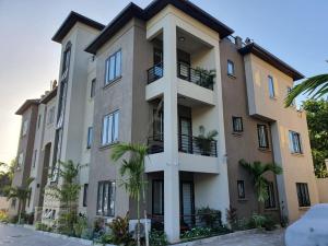 a building with palm trees in front of it at lovely gated 3 BEDROOM in Kingston