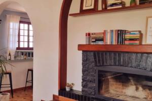 sala de estar con chimenea y estante para libros en Ullasa house - Inolvidables vistas panorámicas del mar en Vilagarcía de Arousa